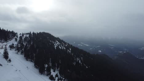 Unglaubliche-Landschaft-Mit-Bergen-Voller-Kiefern-Und-Schnee-Und-Einem-Nebligen-Himmel-Bei-Winterlichem-Schneefall