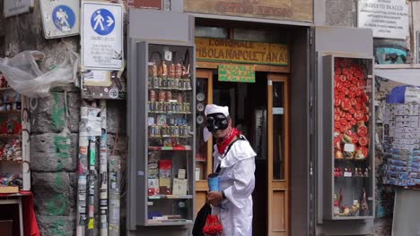 Mann-In-Weißem-Kostüm-Und-Maskerademaske-Vor-Dem-Kuriositätenladen