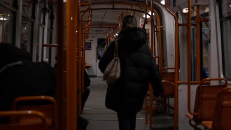 Woman-Walking-In-Public-Tram-At-Night
