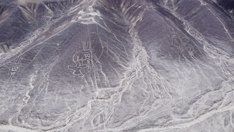 Humanoid-creatures-in-Nazca,-top-down-aerial-view-of-valley-in-Peru