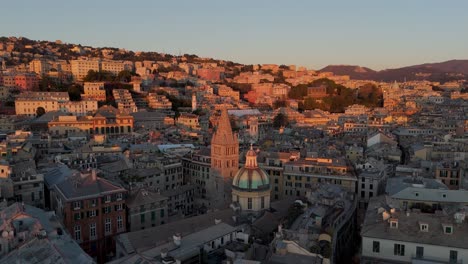 Golden-hour-over-Genoa's-historic-center-with-warm-light-bathing-the-buildings,-aerial-view