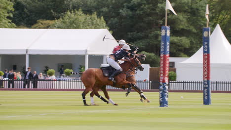 Polo-player-scores-a-goal-by-hitting-ball-into-the-air-whilst-opposing-player-chases-him-down