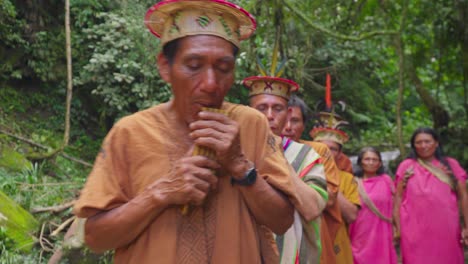 Hombres-Indígenas-Tocando-Flauta-Con-Un-Grupo-De-Mujeres-Vestidas-Tradicionales,-Oxapampa,-Perú,-Durante-El-Día,-Ceremonia-Cultural.