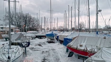 Aerial-view-of-winter-covered-sailboats,-winter-evening-in-Michigan,-USA