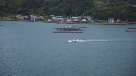 Boat-passing-Island-in-Toba-Bay-and-Oyster-Farms,-Mie-Prefecture-Japan