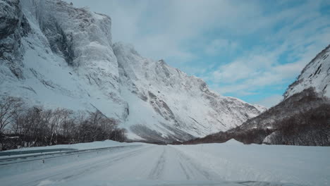 POV-footage-of-a-scenic-winter-drive,-featuring-snowy-mountain-roads-and-the-impressive-view-of-Trollveggen