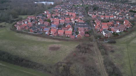 Aerial-shot-of-a-residential-area-in-Norwich-with-distinct-red-rooftops-and-surrounding-greenery,-early-evening-light