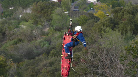 Paramedic-hanging-from-a-helicopter,-rescue-mission-in-Los-Angeles,-CA,-USA