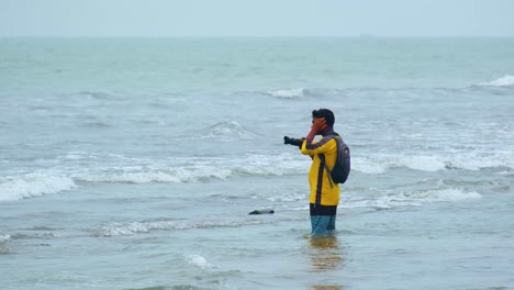 A-photographer-takes-pictures-in-the-Indian-Ocean-in-the-waters-of-Kuakata-region,-Bangladesh