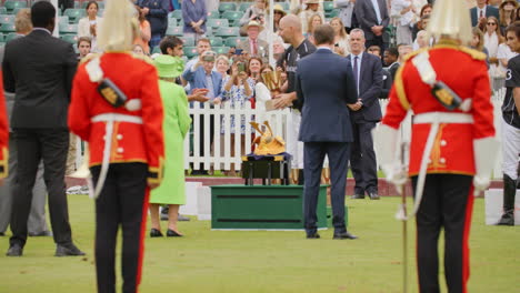 Queen-Elizabeth-II-watches-polo-player-pick-up-trophy-and-bow