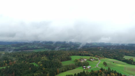 Foggy-Landscape-With-Village-And-Forests-During-Autumn---Aerial-Shot