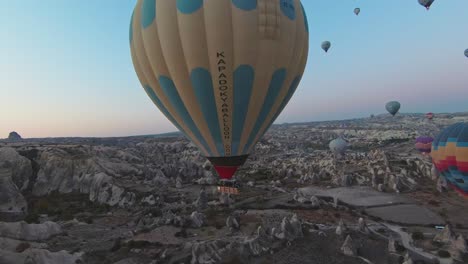 Hot-Air-Balloons-Flying-In-Cappadocia,-Turkey-During-Sunrise---Aerial-FPV