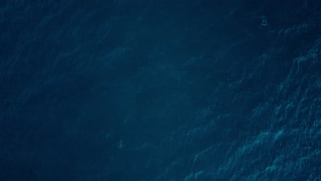 Deep-blue-ocean-textures-from-a-high-vantage-point,-waves-creating-subtle-patterns