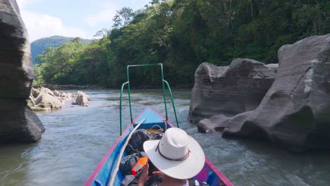 Boat-steering-through-river-canyons-in-Oxapampa,-Peru-with-lush-greenery