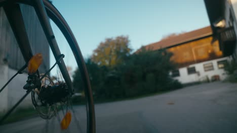 Bicycle-wheel-POV-with-blurred-background-of-a-suburban-area-at-dusk