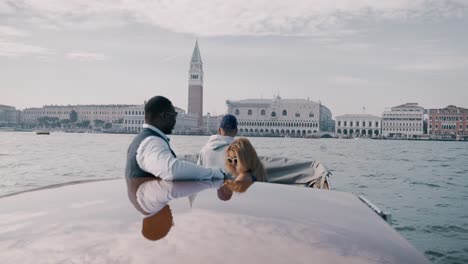 A-mixed-race-couple-having-a-private-boat-trip-exploring-Venice-italy-and-enjoying-the-view-of-the-scenic-city-in-front-of-Palazzo-Ducale-and-Ponte-della-Paglia