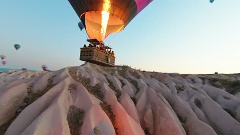 Rocky-Landscape-Of-Cappadocia-With-Flying-Hot-Air-Balloons-In-Turkey---Drone-FPV