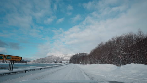 POV-Aufnahmen-Einer-Winterfahrt,-Die-Verschneite-Bergstraßen-Und-Die-Atemberaubende-Aussicht-Auf-Fjorde-Unter-Einem-Klaren-Blauen-Himmel-Zeigen