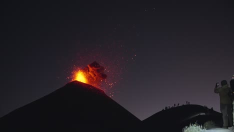 Massiver-Vulkanausbruch-Des-Fuego-In-Der-Nacht,-Bei-Dem-Zuschauer-Das-Spektakel-Aus-Explodierender,-Glühender-Lava-Und-Asche-Festhielten