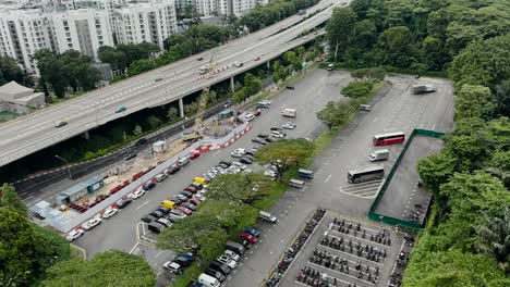 Deslizándose-Sobre-La-Autopista-De-La-Costa-Oeste-Y-Un-Aparcamiento-En-Singapur---Toma-Aérea-De-Un-Drone