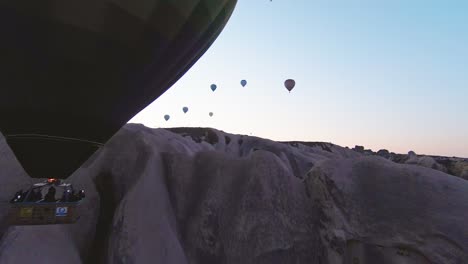 Hot-Air-Balloons-Flying-During-Sunrise-In-Cappadocia,-Turkey---Drone-FPV