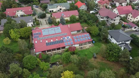 Großes-Haus-Inmitten-Von-Bäumen-Mit-Sonnenkollektoren-Auf-Dem-Dach,-Die-Nachhaltige-Energie-Erzeugen