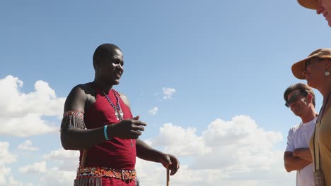 Grupo-De-Turistas-Escuchando-A-Un-Hombre-Masai-En-Kenia,-África