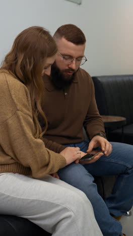 Happy-couple-with-device-indoors