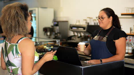 Waitress-giving-take-away-coffee-to-woman