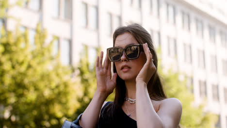 Junge-Modische-Frau,-Die-Auf-Der-Straße-Die-Sonnenbrille-Aufsetzt