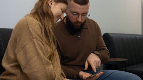 Happy-couple-with-device-indoors