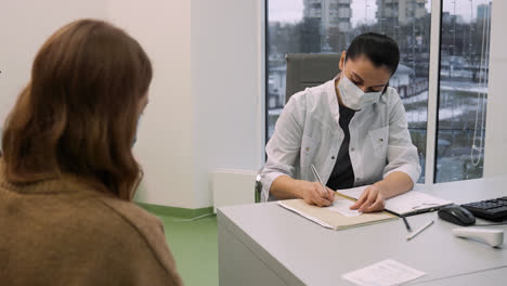 Doctor-writing-prescription-for-patient