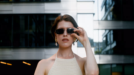 Front-view-of-elegant-woman-putting-the-sunglases-on