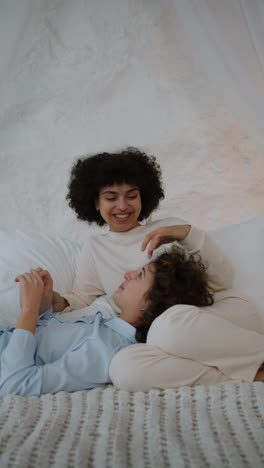 Happy-couple-talking-on-bed