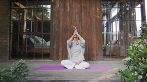 Mujer-Birracial-Enfocada-Practicando-Yoga-En-La-Terraza,-Cámara-Lenta