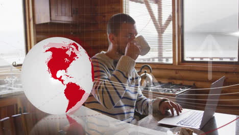 Animation-of-rotating-globe,-up-arrows-over-caucasian-man-drinking-coffee-while-working-on-laptop