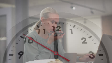 Animation-of-ticking-clock-against-caucasian-woman-talking-on-smartphone-at-office