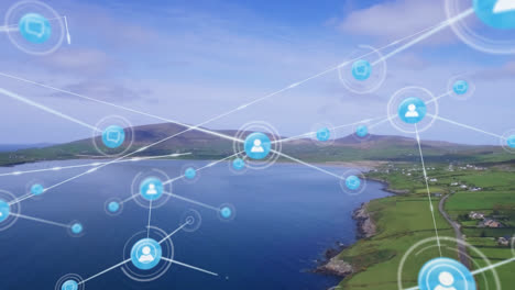 Animation-of-network-of-digital-icons-over-aerial-view-of-landscape-with-mountain,-grassland-and-sea