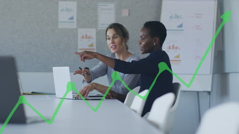 Animation-of-green-graph-over-diverse-female-coworkers-discussing-reports-on-laptop-in-office