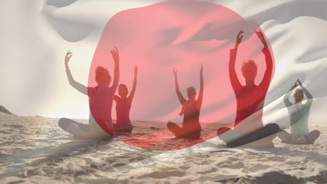 Zusammengesetztes-Video,-In-Dem-Die-Japanische-Flagge-Gegen-Eine-Gruppe-Von-Menschen-Geschwenkt-Wird,-Die-Am-Strand-Yoga-Praktizieren