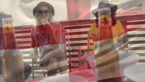Composite-video-of-waving-england-flag-against-group-of-diverse-friends-drinking-beer-together
