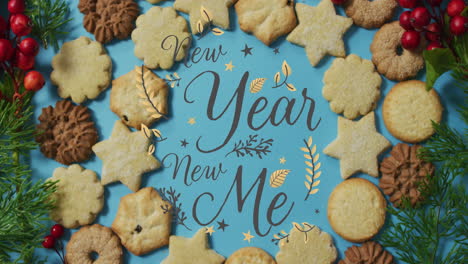 Animation-of-new-year-new-me-text-over-christmas-cookies-on-blue-background