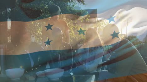 Composite-video-of-waving-honduras-flag-against-group-of-diverse-colleagues-discussing-at-a-cafe