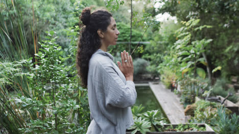 Fokussierte-Biracial-Frau,-Die-Yoga-Im-Sonnigen-Garten-Praktiziert,-Zeitlupe