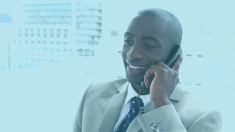 Animation-of-data-processing-over-african-american-businessman-talking-on-smartphone-at-office