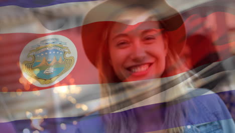 Video-Compuesto-De-Ondear-La-Bandera-De-Costa-Rica-Sobre-Una-Feliz-Mujer-Caucásica-Celebrando-Con-Bengala