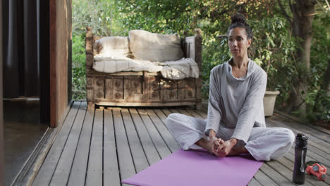 Fokussierte-Biracial-Frau,-Die-Yoga-Auf-Der-Terrasse-Praktiziert,-Zeitlupe-Mit-Kopierraum