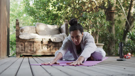 Fokussierte-Biracial-Frau,-Die-Yoga-Auf-Der-Terrasse-Praktiziert,-Zeitlupe