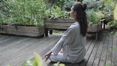 Focused-biracial-woman-practicing-yoga-meditation-in-sunny-garden,-slow-motion-with-copy-space