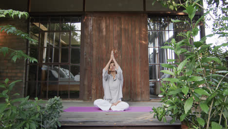 Fokussierte-Biracial-Frau,-Die-Yoga-Auf-Der-Terrasse-Praktiziert,-Zeitlupe